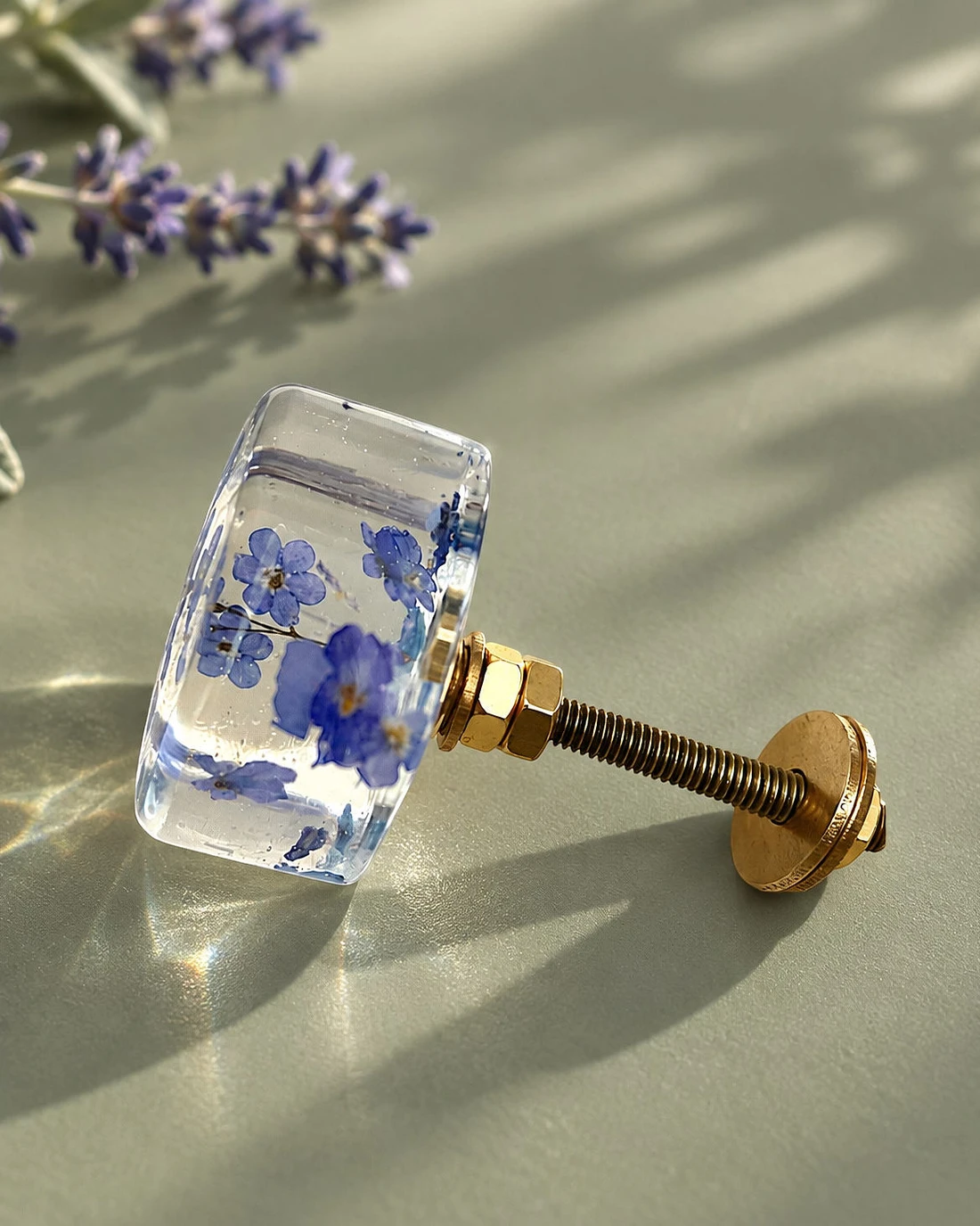 Gałka meblowa Lawenda (Lavandula officinalis) · gałka ze śrubą na szałwiowym tle, obok lawenda