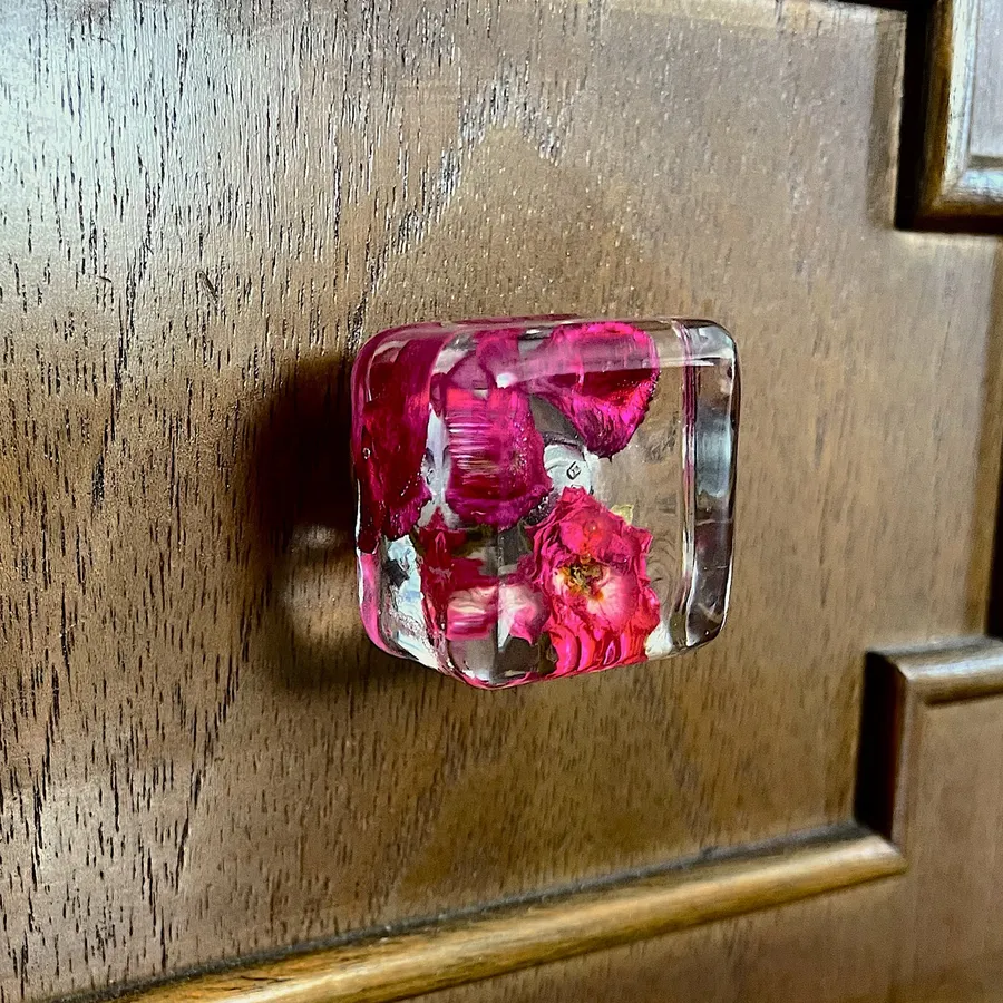Gałka meblowa Pralines z zasuszonymi płatkami róży w żywicy na szufladzie drewnianej komody
